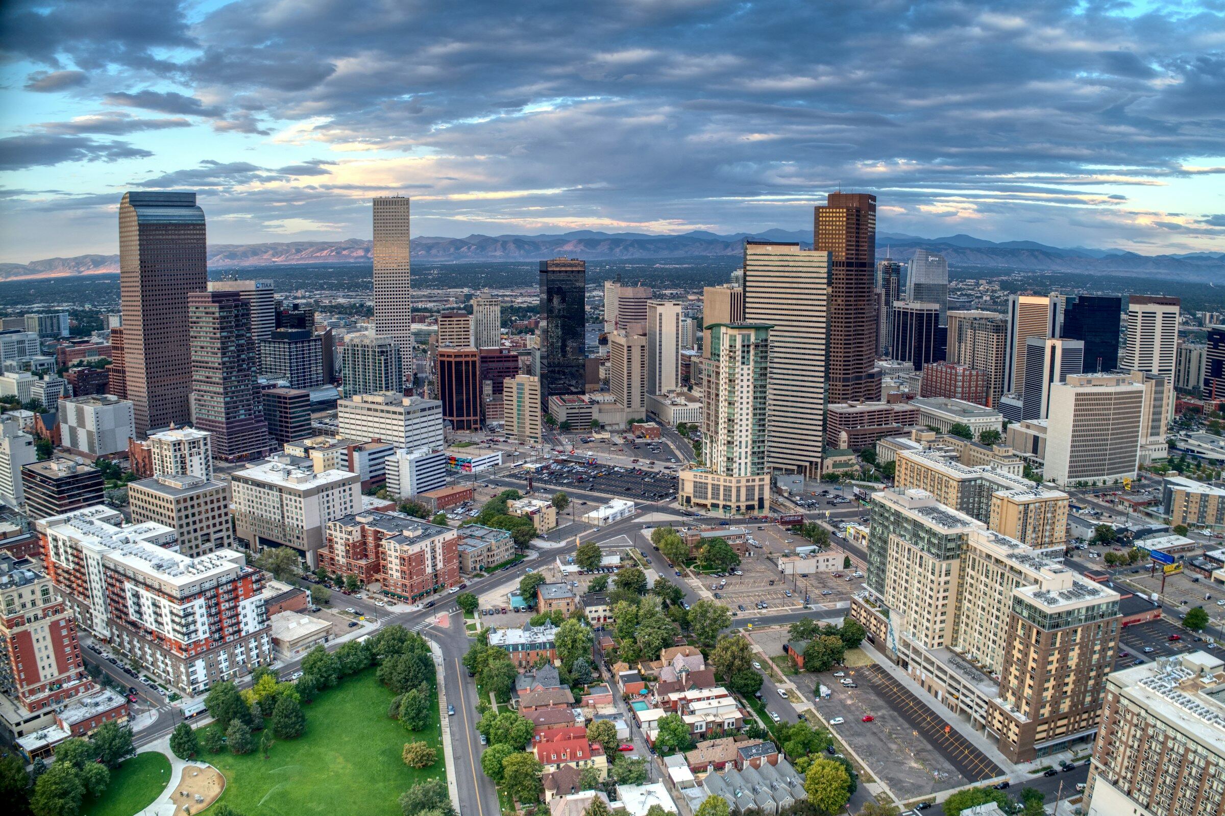 Downtown Denver at dusk with the Front Range behind